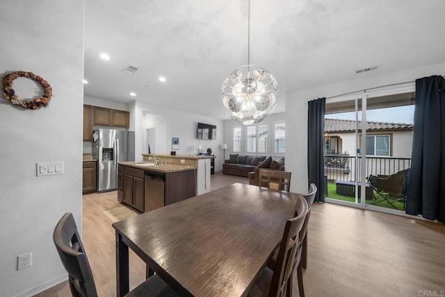 dining room with visible vents, a notable chandelier, light wood finished floors, and recessed lighting