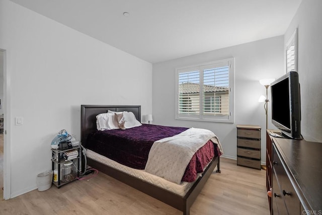 bedroom with light wood-style floors and baseboards