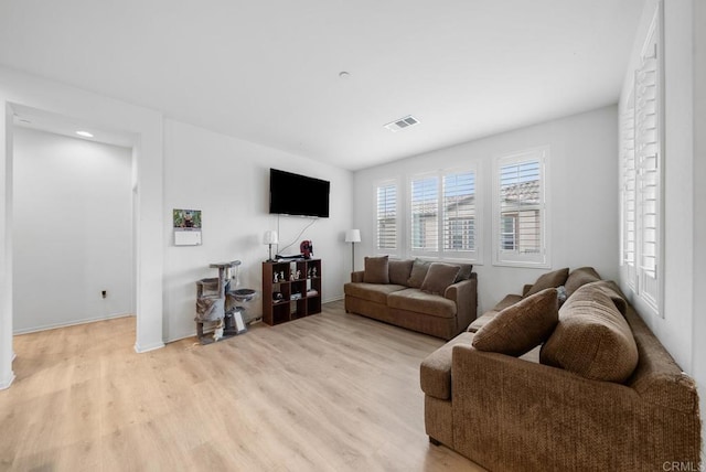living area with visible vents, baseboards, and light wood-style floors