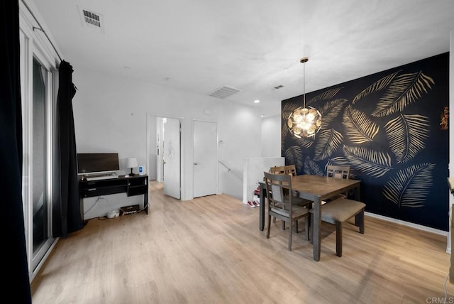 dining area featuring a notable chandelier, visible vents, and light wood-type flooring