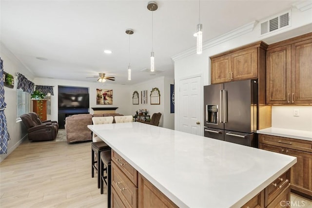 35183 Flamingo Way, Winchester, CA 92596 - kitchen featuring high end fridge, light countertops, light wood-style floors, a kitchen island, and decorative light fixtures