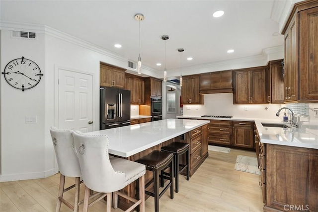 35183 Flamingo Way, Winchester, CA 92596 - kitchen with appliances with stainless steel finishes, a center island, light wood-type flooring, a breakfast bar area, and light countertops