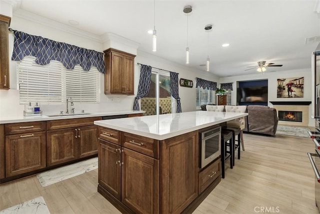 35183 Flamingo Way, Winchester, CA 92596 - kitchen with a sink, stainless steel microwave, ceiling fan, ornamental molding, and light wood-style floors
