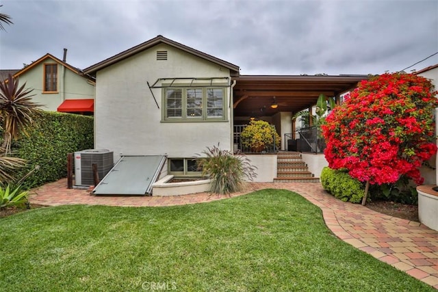 1956 E Woodlyn Rd, Pasadena, CA 91104 - rear view of house with a lawn, central air condition unit, and stucco siding
