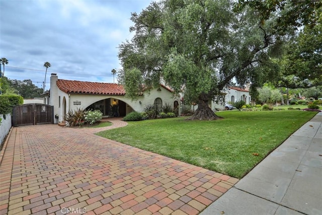 1956 E Woodlyn Rd, Pasadena, CA 91104 - mediterranean / spanish-style house with a tiled roof, stucco siding, decorative driveway, and a front yard