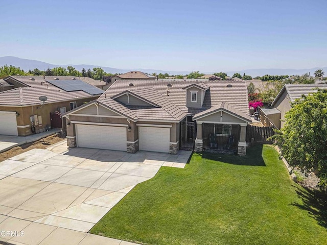 10909 Rainwater Ln, Bakersfield, CA 93306 - view of front of house featuring fence, driveway, stone siding, a front lawn, and an attached garage