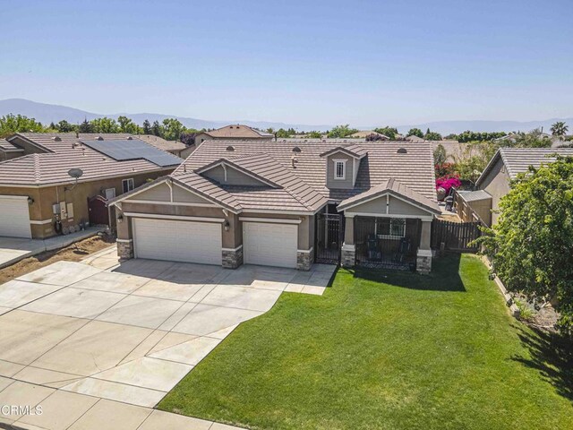 10909 Rainwater Ln, Bakersfield, CA 93306 - view of front facade featuring stone siding, concrete driveway, an attached garage, a tiled roof, and stucco siding