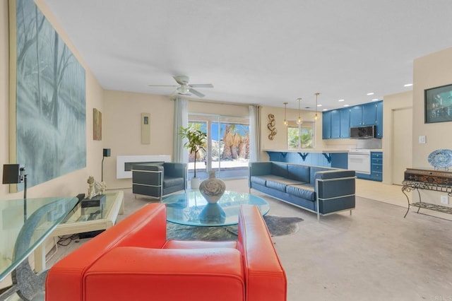 living room with a ceiling fan and concrete flooring