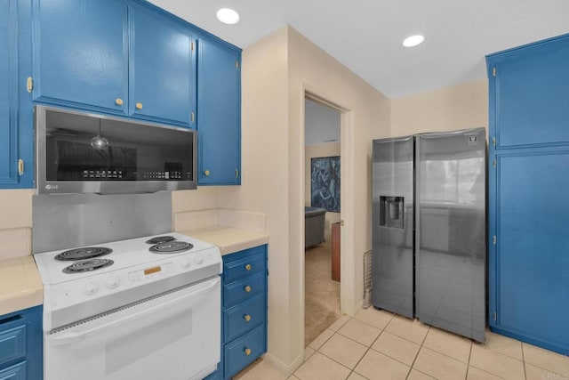 kitchen featuring stainless steel appliances, blue cabinetry, light countertops, and recessed lighting