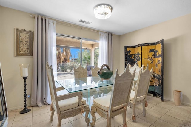 dining space with light tile patterned flooring, a chandelier, and baseboards