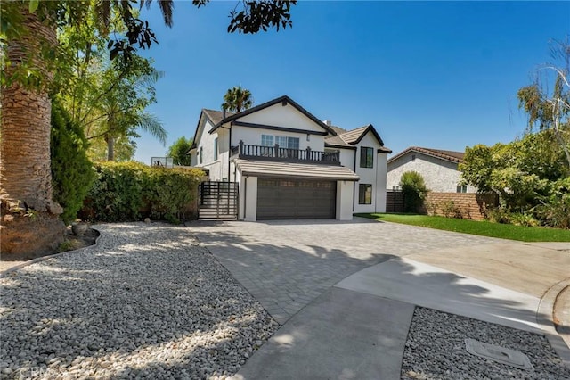 20500 Blairmoore St, Chatsworth, CA 91311 - view of front of house featuring a balcony, stucco siding, decorative driveway, and an attached garage