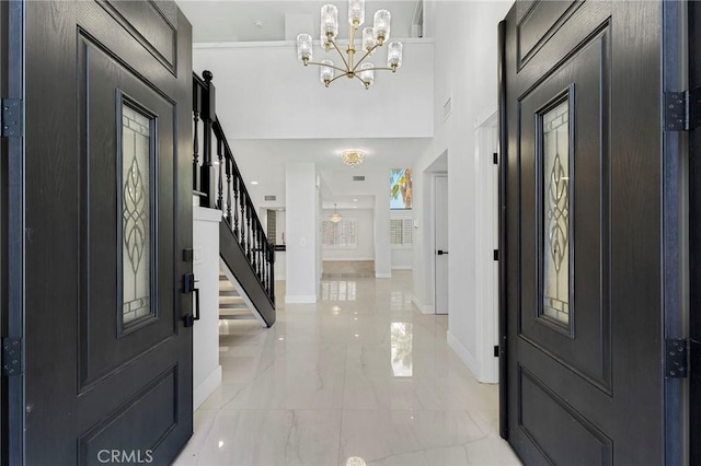 20500 Blairmoore St, Chatsworth, CA 91311 - foyer entrance with light marble finish floors, stairway, a chandelier, and baseboards