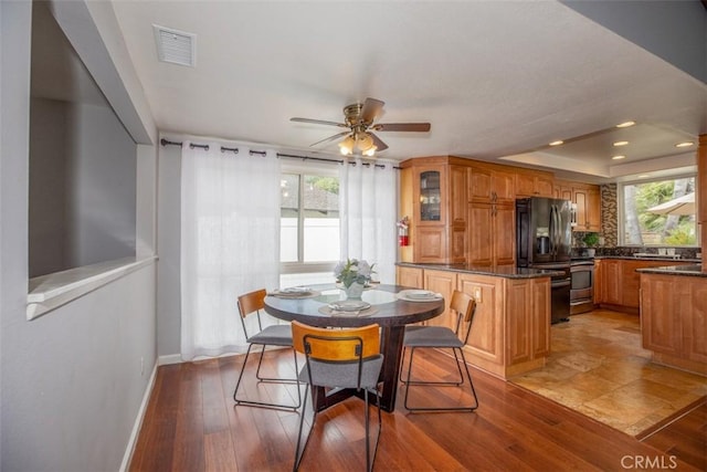 dining space featuring a ceiling fan, visible vents, baseboards, and a healthy amount of sunlight