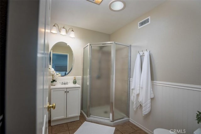 bathroom with tile patterned flooring, visible vents, a shower stall, and vanity