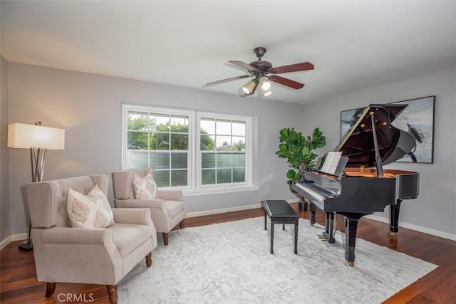 sitting room with ceiling fan, dark wood finished floors, and baseboards