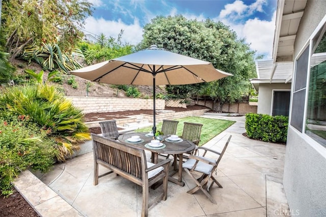 view of patio with outdoor dining space and fence