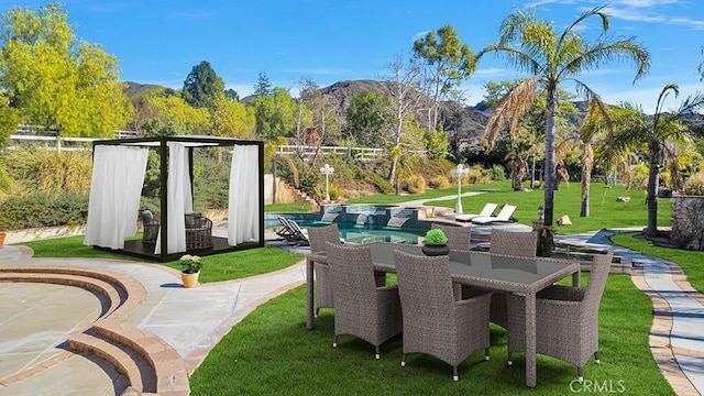 view of patio with a mountain view, outdoor dining space, and an outdoor pool