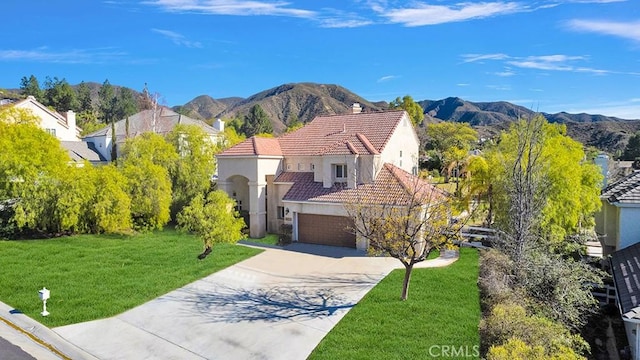traditional-style house featuring stucco siding, a tiled roof, a garage, driveway, and a mountain view