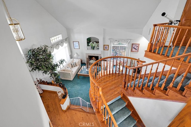 stairway featuring a tiled fireplace and wood finished floors