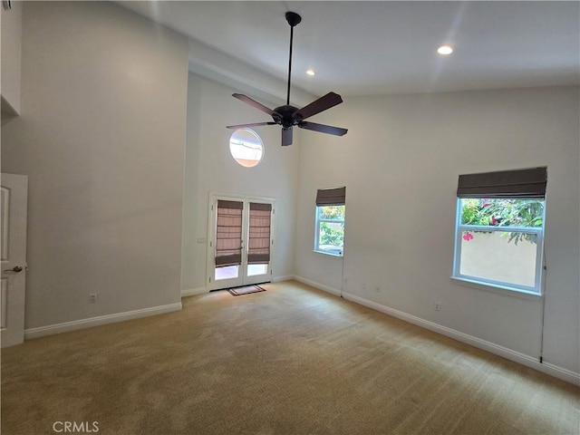 spare room with recessed lighting, light colored carpet, ceiling fan, baseboards, and high vaulted ceiling
