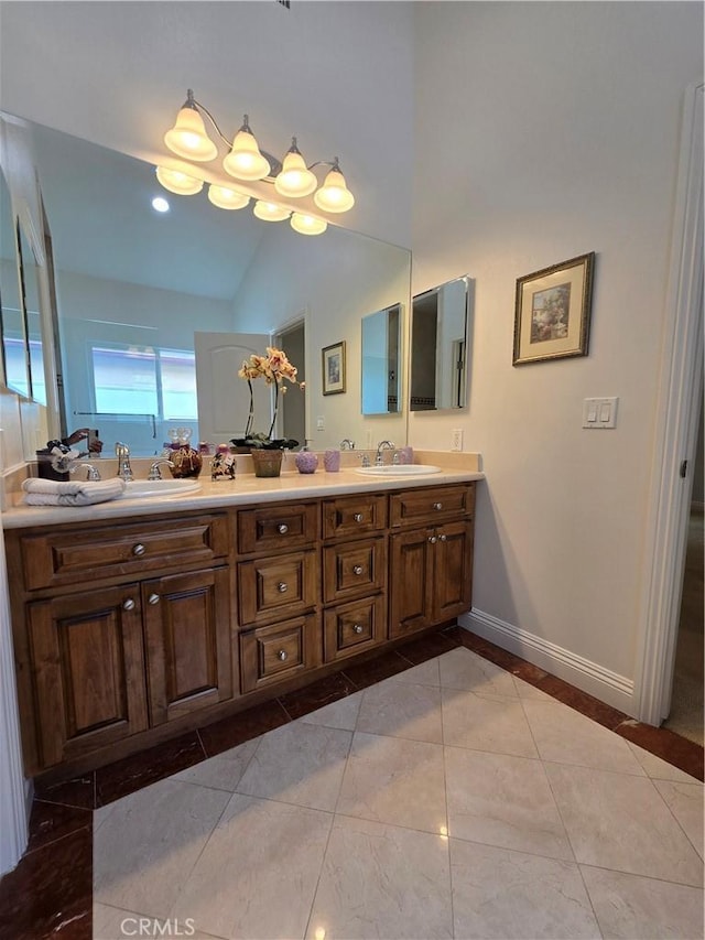 bathroom featuring tile patterned floors, baseboards, double vanity, and a sink