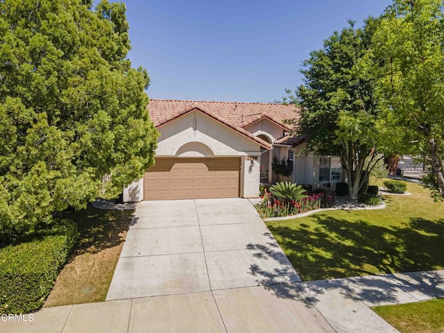 mediterranean / spanish-style house featuring concrete driveway, a tile roof, an attached garage, stucco siding, and a front lawn