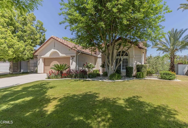 mediterranean / spanish home with a garage, a front lawn, stucco siding, and driveway