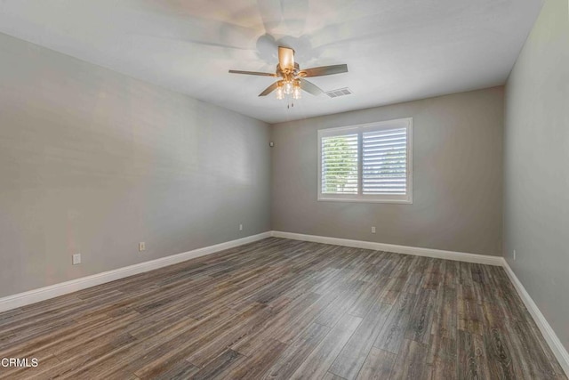 unfurnished room featuring wood finished floors, visible vents, a ceiling fan, and baseboards