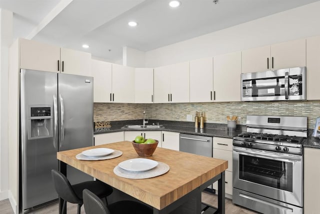 1551 4th Ave Unit 611, San Diego, CA 92101 - kitchen with a sink, dark countertops, backsplash, and stainless steel appliances