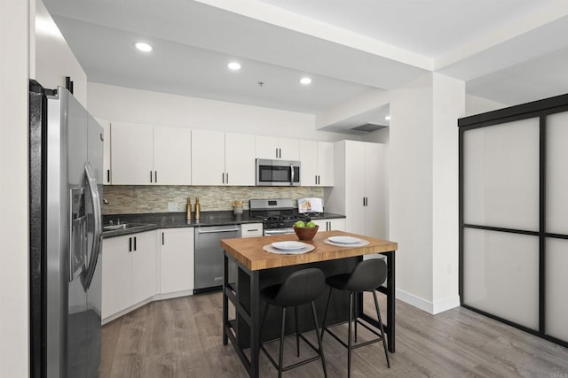 1551 4th Ave Unit 611, San Diego, CA 92101 - kitchen featuring light wood-type flooring, white cabinetry, appliances with stainless steel finishes, and tasteful backsplash