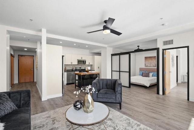 1551 4th Ave Unit 611, San Diego, CA 92101 - living room featuring visible vents, baseboards, recessed lighting, a ceiling fan, and light wood-style flooring