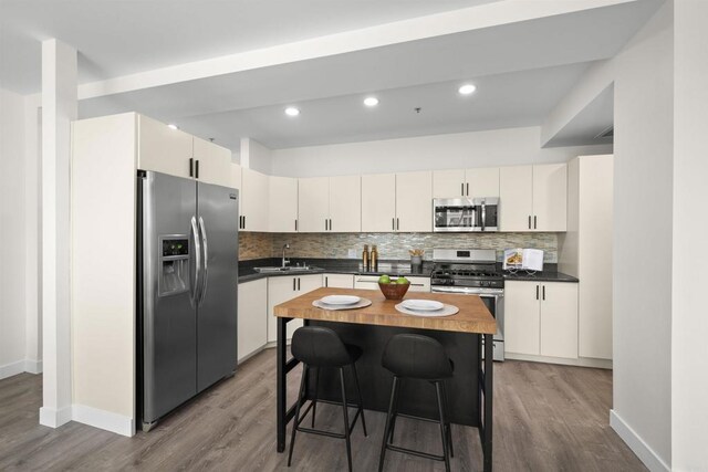 1551 4th Ave Unit 611, San Diego, CA 92101 - kitchen with baseboards, appliances with stainless steel finishes, a sink, and wood finished floors
