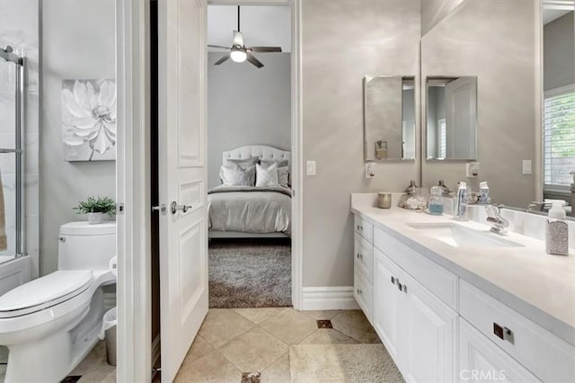 ensuite bathroom featuring vanity, toilet, ceiling fan, connected bathroom, and tile patterned floors