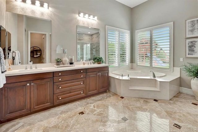bathroom featuring a sink, double vanity, marble finish floor, a shower stall, and a bath