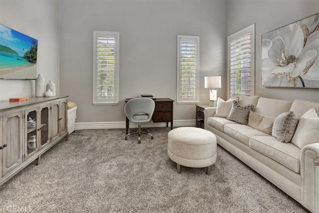 carpeted living room featuring baseboards