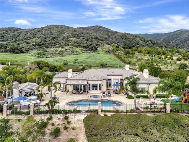 view of pool featuring fence, a fenced in pool, a mountain view, and a patio