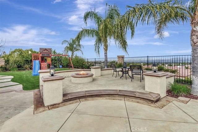 view of patio / terrace featuring fence, an outdoor fire pit, and playground community
