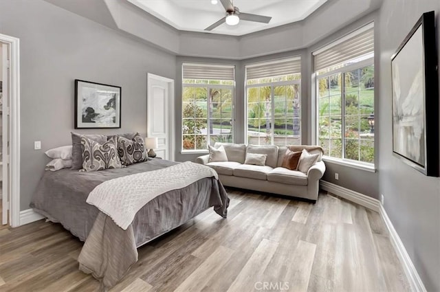 bedroom with baseboards, light wood-style floors, and ceiling fan