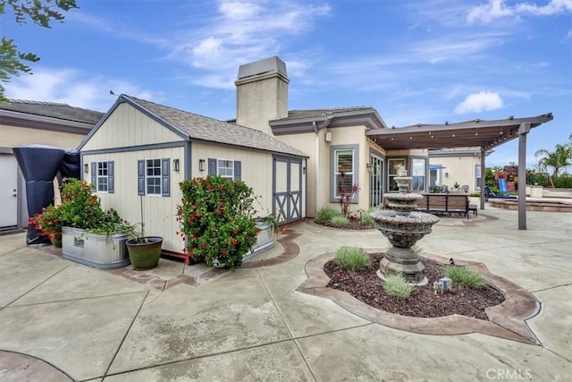 rear view of house featuring a patio and a chimney