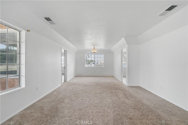 spare room with carpet flooring, a chandelier, and visible vents