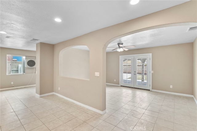 spare room featuring light tile patterned floors, a textured ceiling, french doors, and baseboards