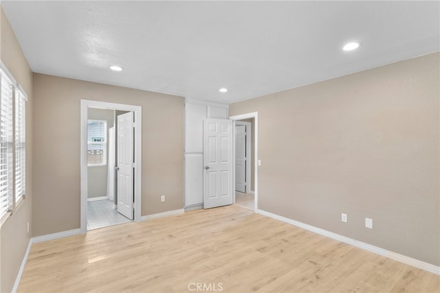 unfurnished bedroom featuring light wood-type flooring, recessed lighting, and baseboards