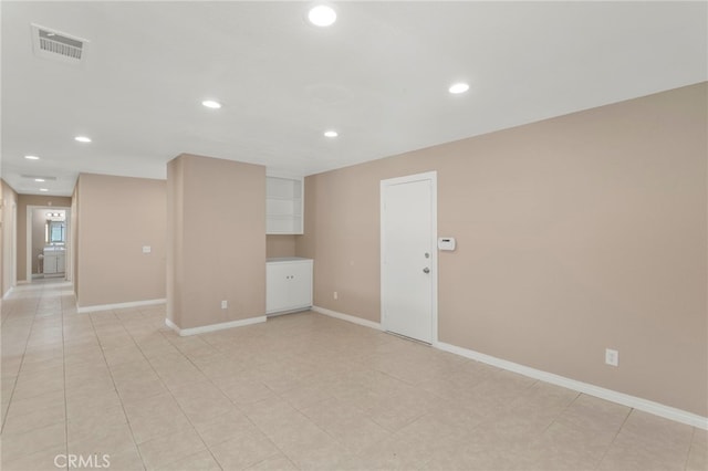 empty room with baseboards, visible vents, light tile patterned floors, and recessed lighting
