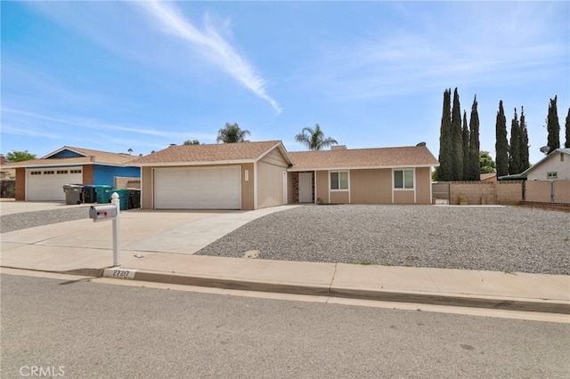 ranch-style home with fence, concrete driveway, and a garage