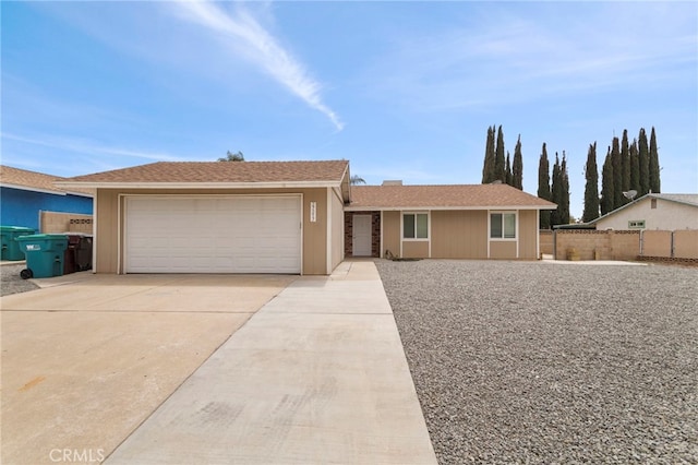 ranch-style home with fence, driveway, and an attached garage