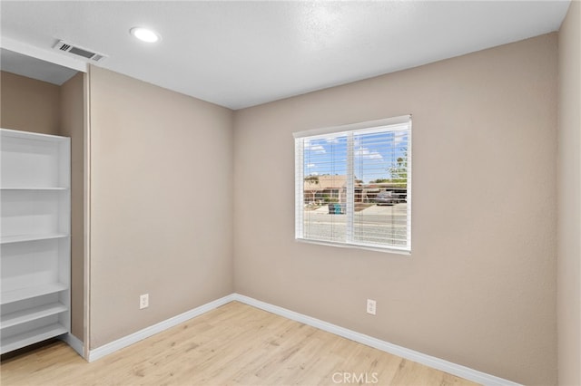 spare room featuring baseboards, visible vents, wood finished floors, and recessed lighting