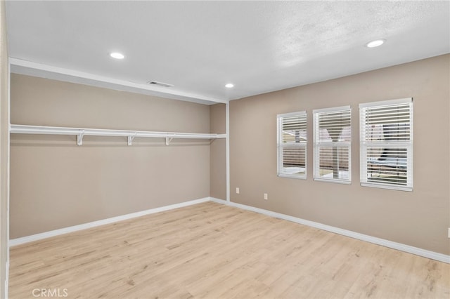 unfurnished bedroom with wood finished floors, visible vents, and recessed lighting