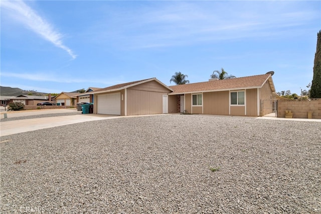 ranch-style house featuring driveway, a garage, and fence