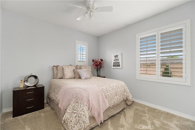 bedroom featuring ceiling fan, light colored carpet, and baseboards