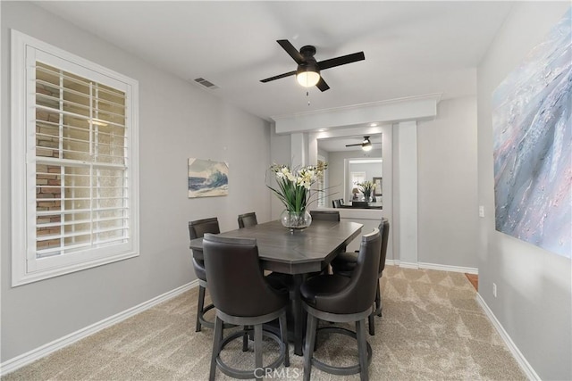 dining area featuring visible vents, ceiling fan, light colored carpet, and baseboards